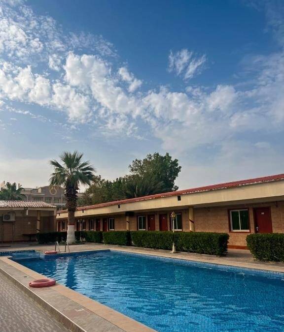 Outdoor swimming pool with palm trees at Marhaba Hotel And Resort